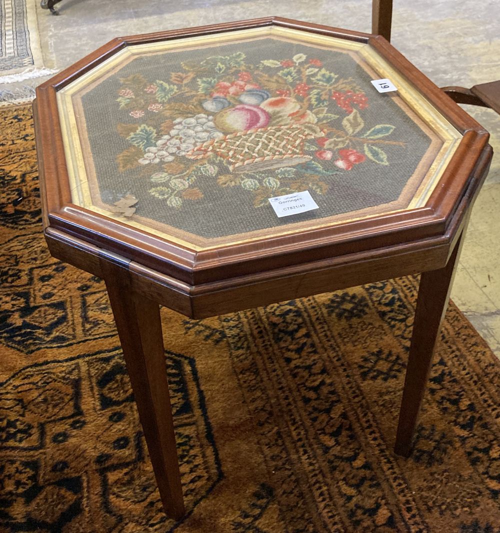 An grois point tapestry panel, inset in the top of a hexagonal mahogany table, width 54cm, depth 48cm, height 48cm